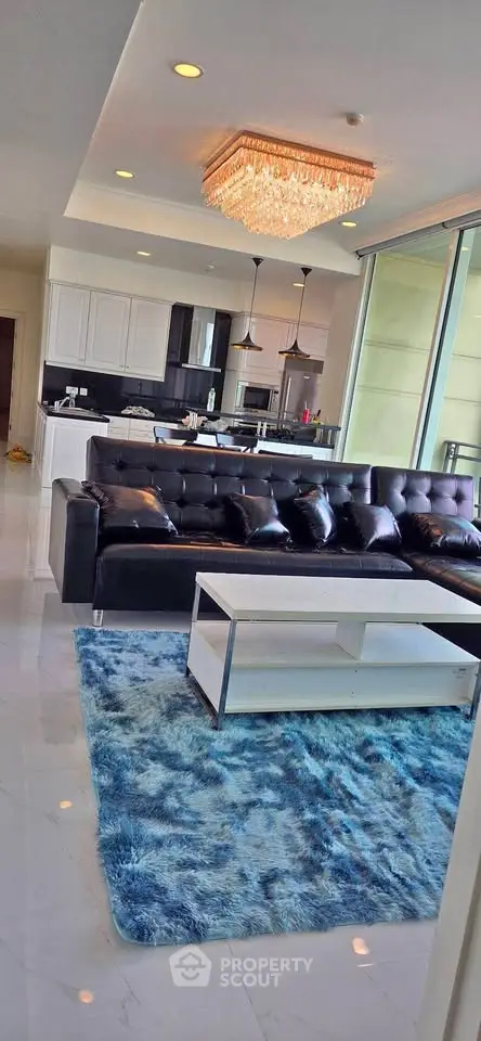 Luxurious living room with modern kitchen and elegant chandelier