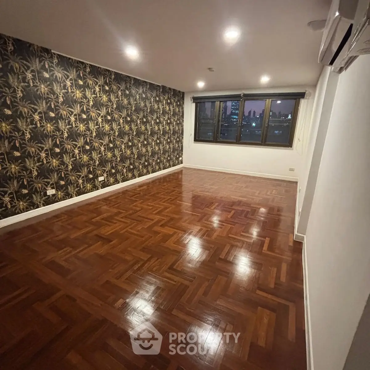 Spacious living room with elegant parquet flooring and city view.