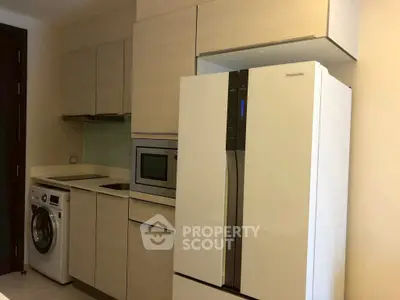 Modern kitchen with sleek appliances including fridge, oven, and washing machine.