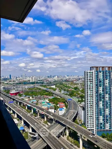 Stunning cityscape view from high-rise balcony with clear skies and urban skyline.