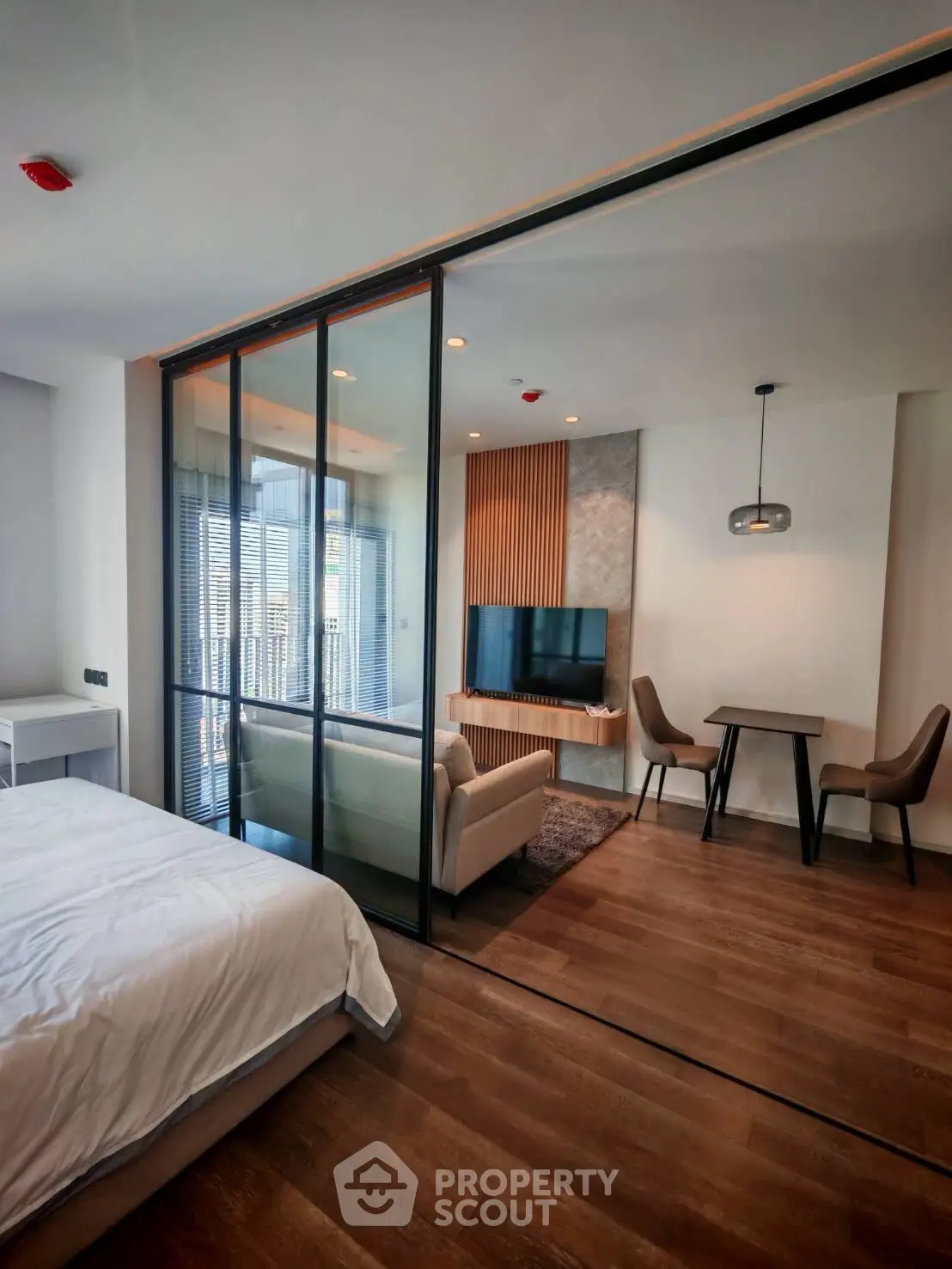 Modern studio apartment with glass partition, cozy living area, and stylish decor
