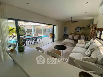 Spacious living room with pool view, modern decor, and open layout for luxurious living.