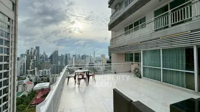 Stunning cityscape view from spacious high-rise balcony with modern outdoor seating.
