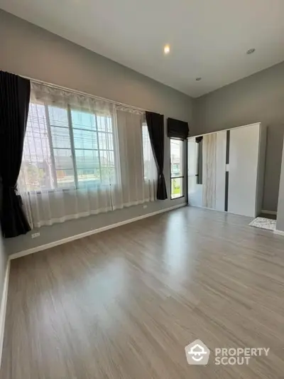 Spacious empty room with large windows and modern flooring