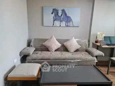 Modern living room with stylish grey sofa and horse artwork, perfect for cozy relaxation.