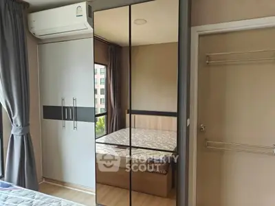 Modern bedroom with mirrored wardrobe and air conditioning in a stylish apartment.