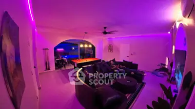 Luxurious living room with modern lighting and pool table, perfect for entertainment and relaxation.