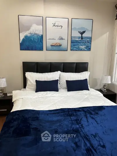 Cozy bedroom with elegant decor and ocean-themed artwork above bed