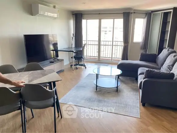 Spacious living room with modern furniture and large windows offering natural light.