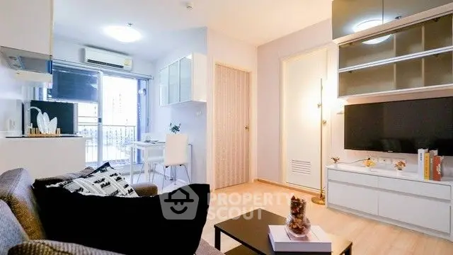 Modern living room with stylish decor and natural light, featuring a cozy sofa and sleek TV setup.