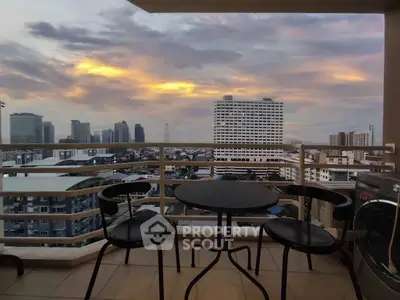 Stunning city view from a high-rise balcony at sunset, perfect for relaxation.