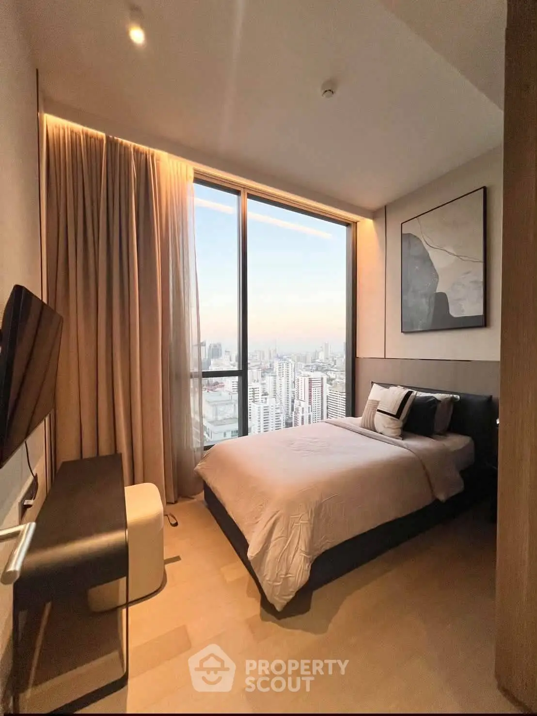 Luxurious bedroom with stunning city view and modern decor in high-rise apartment.