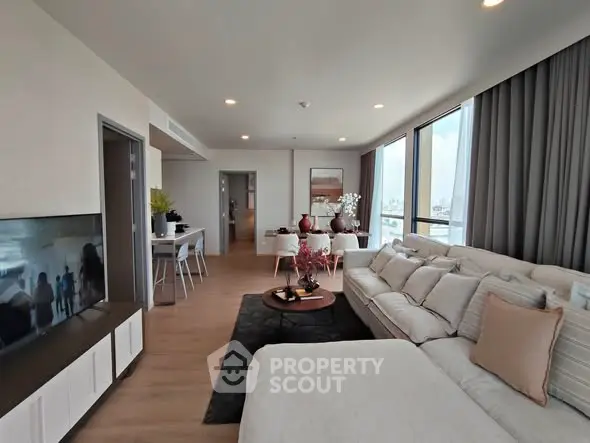 Spacious modern living room with elegant decor and large windows offering natural light.