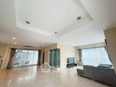 Spacious modern living room with large windows and elegant ceiling design