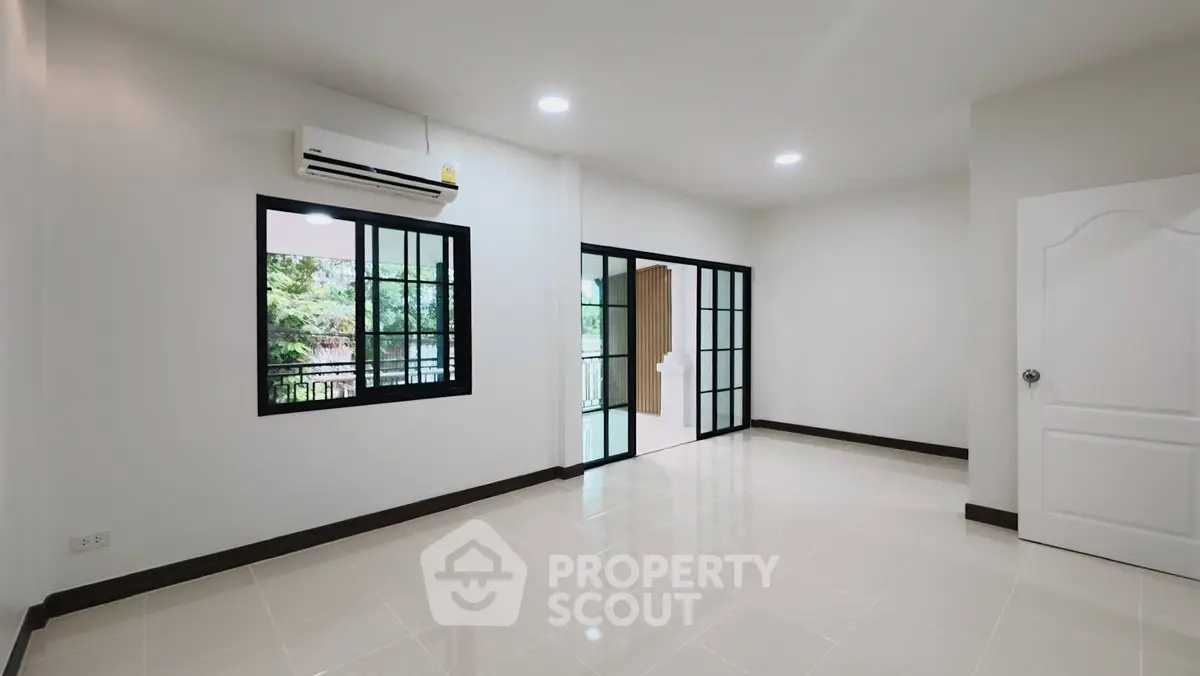 Spacious empty room with large windows and balcony access, ideal for customization.