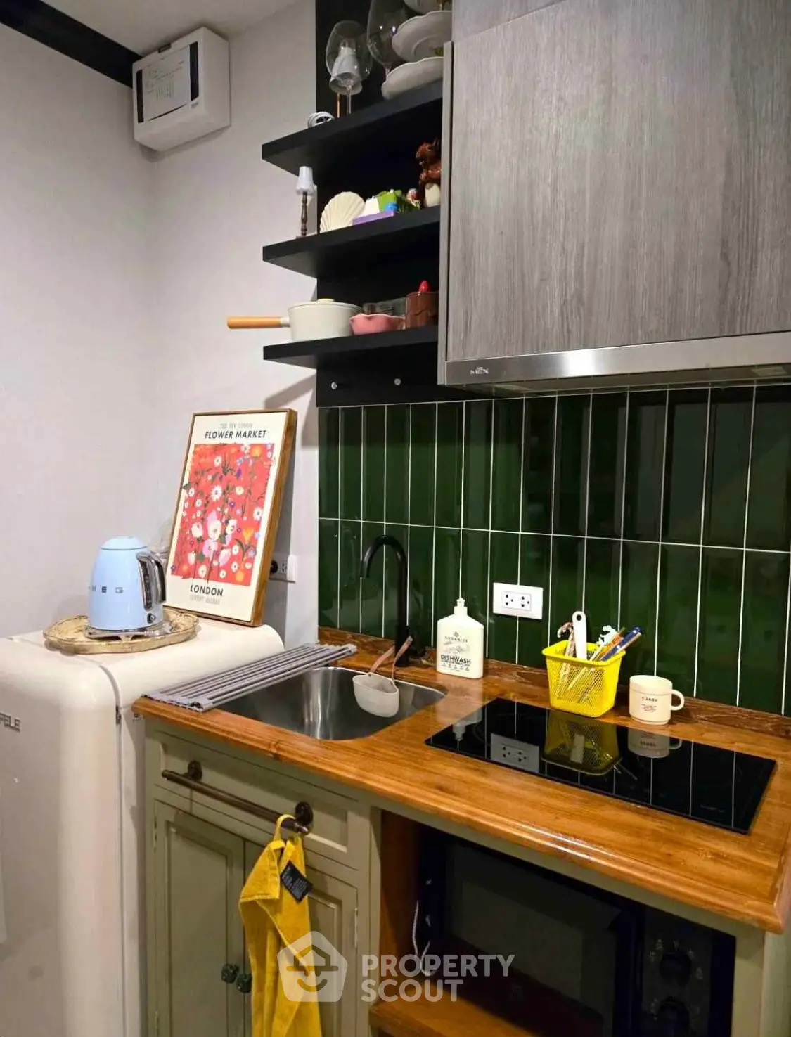 Charming compact kitchen with modern appliances and stylish green tile backsplash.
