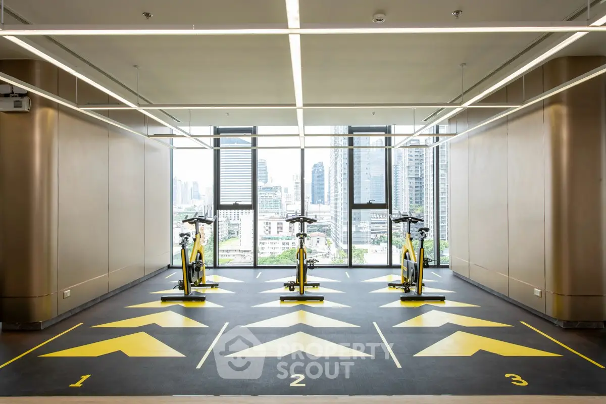 Modern gym with city view featuring stationary bikes and sleek design