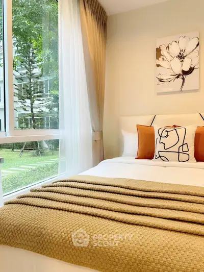 Cozy bedroom with large window overlooking lush garden, featuring elegant decor and warm tones.