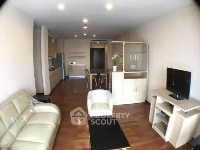 Spacious living room with modern furniture and open kitchen layout in a stylish apartment.