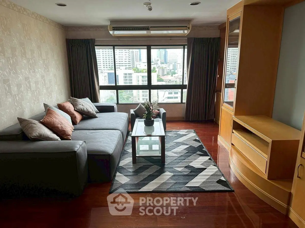 Spacious living room with city view, modern sofa, and elegant decor in urban apartment.