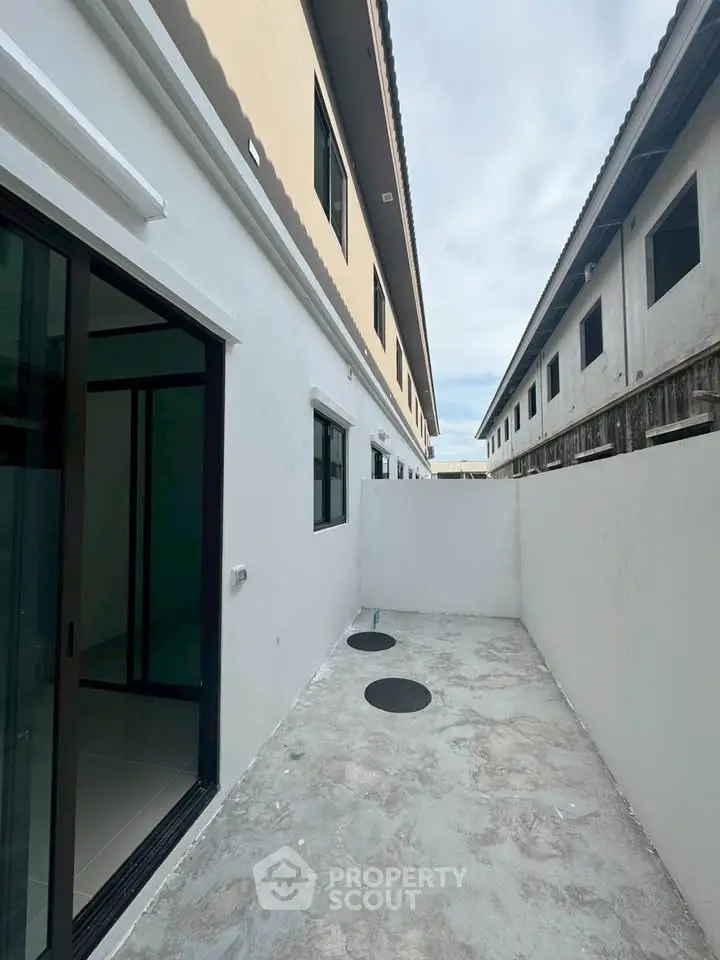 Modern townhouse exterior with clean white walls and sliding glass door