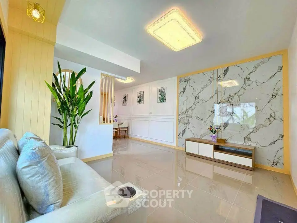 Modern living room with marble accent wall and sleek furniture