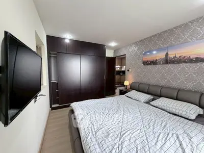 Modern bedroom with stylish decor and wall-mounted TV