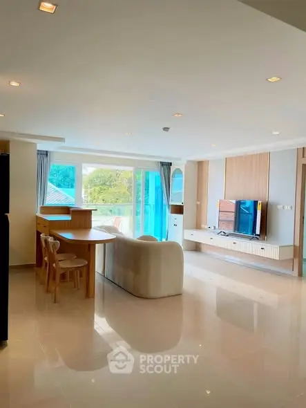 Spacious modern living room with sleek furniture and large windows offering natural light.