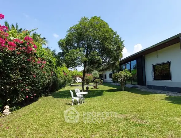 Charming garden view with lush greenery and outdoor seating in a serene residential setting.
