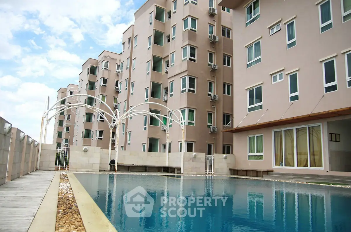 Modern apartment building with a luxurious pool and stylish architecture.