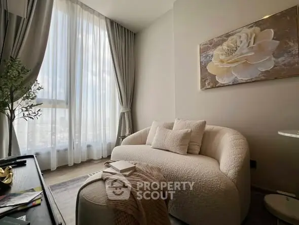 Elegant living room with plush sofa and large window offering natural light.