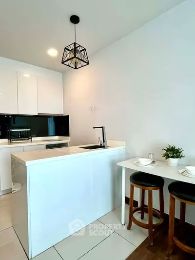 Modern kitchen with sleek white cabinets and stylish pendant lighting