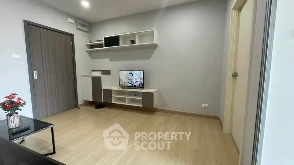 Modern living room with sleek wooden flooring and minimalist TV setup