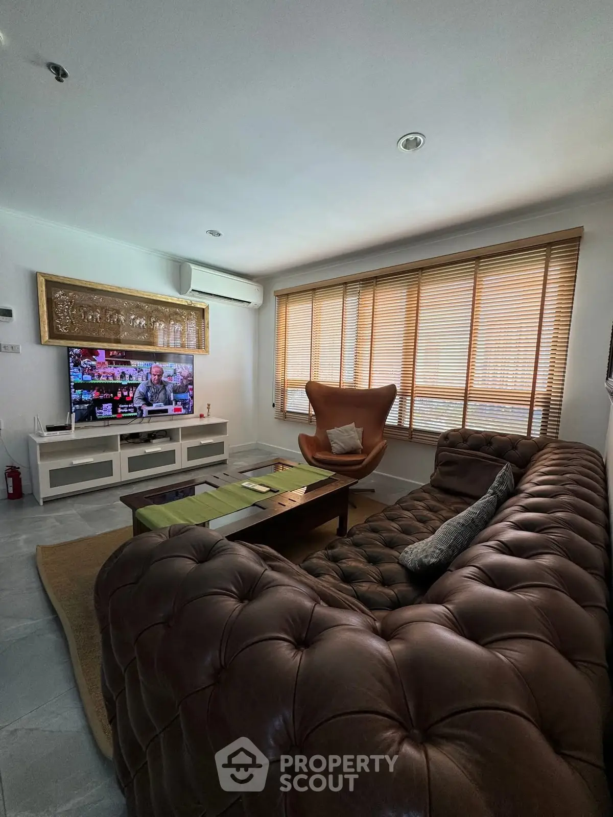 Luxurious living room with leather sofa and large windows for natural light.