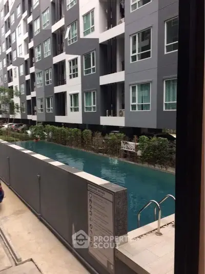 Modern apartment building with sleek pool and lush greenery