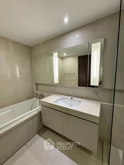 Modern bathroom with sleek vanity and bathtub in luxury apartment