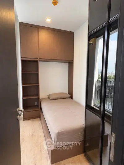 Cozy bedroom with built-in storage and balcony view in modern apartment