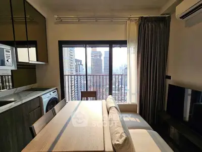 Modern living room with city view, featuring sleek furniture and integrated kitchen appliances.