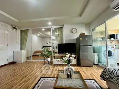 Modern open-plan living room with stylish decor, featuring a cozy bedroom and functional kitchen area.