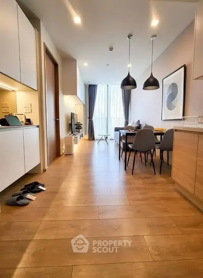 Modern open-plan living and dining area with stylish decor and wooden flooring.