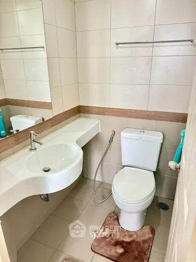 Compact bathroom with modern fixtures and neutral tiles