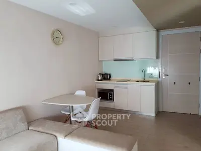 Modern open-layout kitchen with dining area and cozy seating in a stylish apartment.