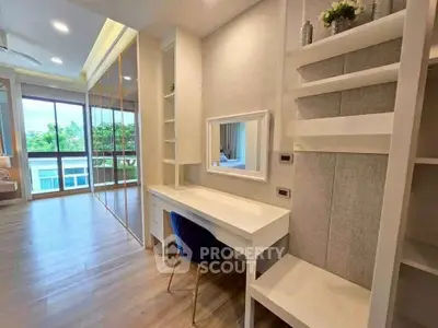 Spacious modern living room with large windows and elegant built-in desk area.