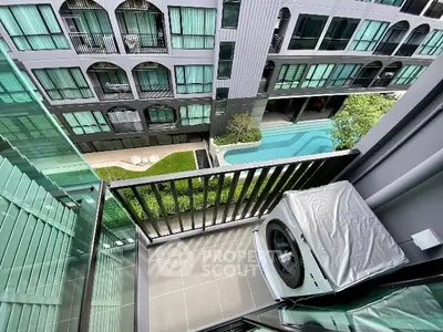 Modern apartment balcony with washing machine and pool view, perfect for urban living.