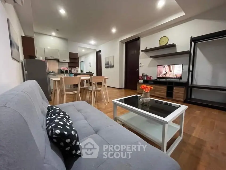 Modern open-layout living room with stylish furniture and kitchen area, perfect for cozy gatherings.