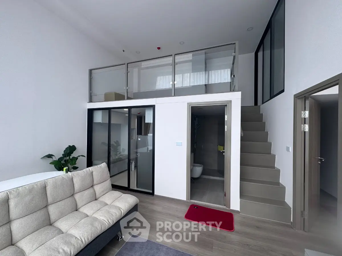 Modern loft apartment with mezzanine, stylish living area, and sleek staircase