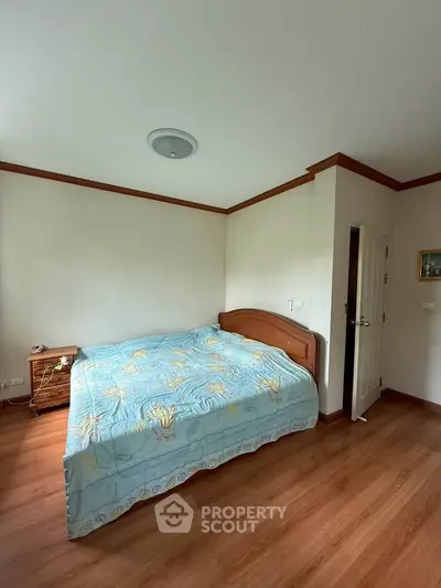 Cozy bedroom with wooden flooring and elegant bed in a serene setting