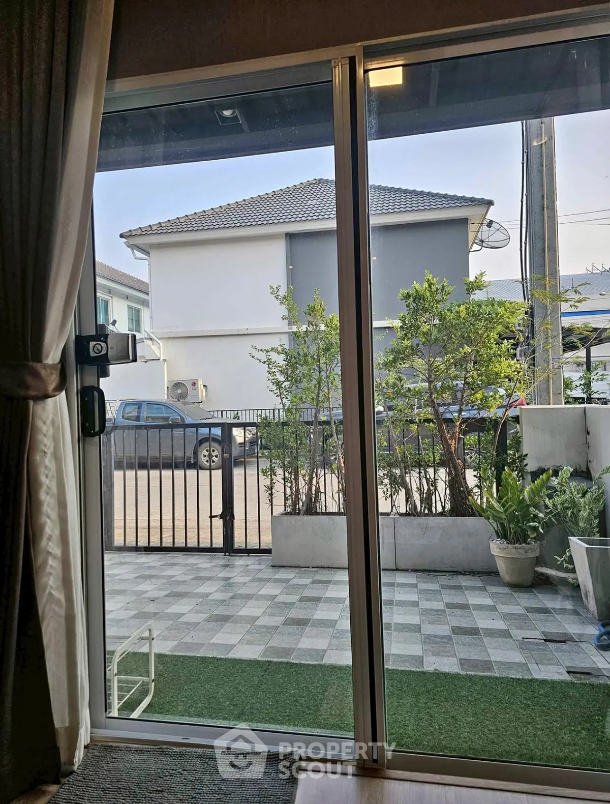 Charming patio view with sliding glass doors and lush greenery