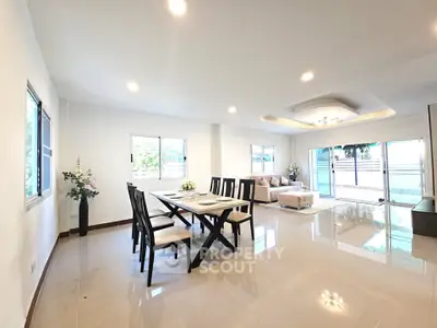 Spacious modern living room with elegant dining area and large windows for natural light.