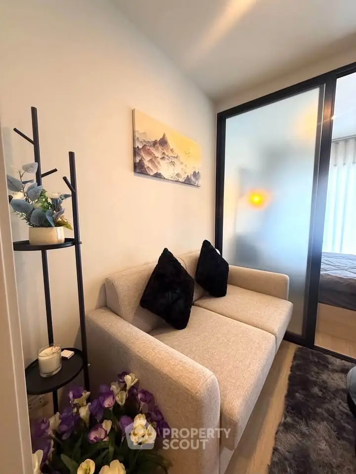 Cozy living room with modern decor and sliding glass door to bedroom